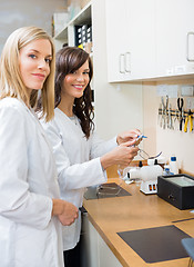 Image showing Confident Opticians Repairing Glasses In Workshop