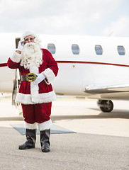 Image showing Santa Using Cell Phone Against Private Jet