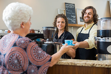 Image showing Waitress With Colleague Serving Coffee To Woman At Counter