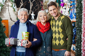 Image showing Happy Parents And Son With Presents Standing In Store