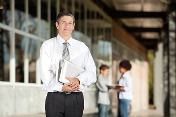 Image showing Teacher Holding Books While Standing On Campus