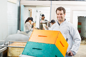 Image showing Beekeeper Holding Trolley Of Stacked Honeycomb Crates