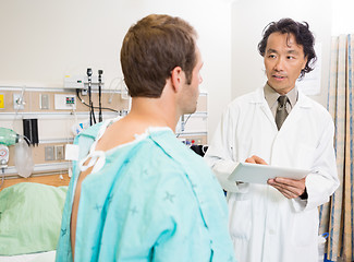 Image showing Doctor Holding Digital Tablet While Discussing Report With Patie