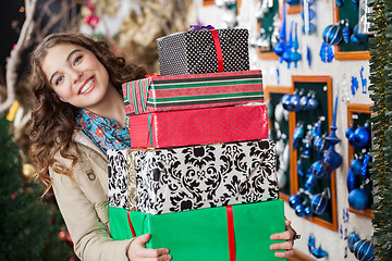 Image showing Happy Woman Carrying Stacked Gift Boxes In Store