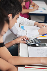 Image showing Schoolboy Using Calculator At Desk