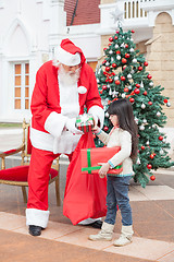 Image showing Girl Taking Presents From Santa Claus