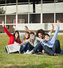 Image showing College Students With Hands Raised Sitting At Campus