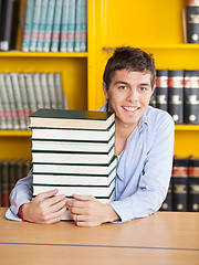 Image showing Student Sitting With Piled Books In University Library