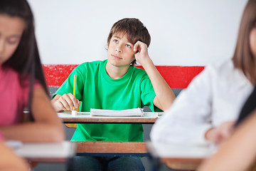 Image showing Thoughtful Teenage Schoolboy Sitting At Desk