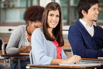 Image showing Student Sitting At Desk With Classmates In Classroom