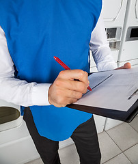 Image showing Male Helper Checking List In Laundry