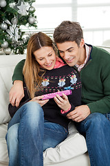 Image showing Smiling Couple Looking At Christmas Gift