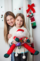 Image showing Mother With Daughter Holding Santa Toy At Home