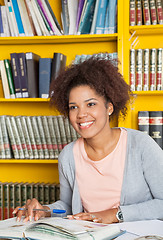 Image showing Student With Books And Pen Looking Away In Library