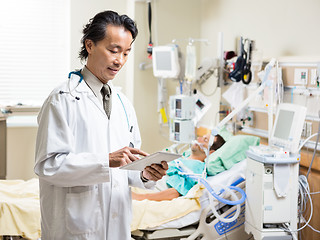 Image showing Doctor Using Digital Tablet While Patient Resting In Hospital