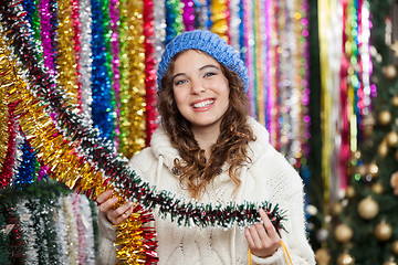 Image showing Young Woman Choosing Tinsels At Store