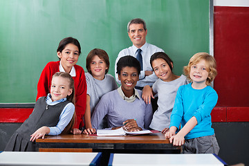 Image showing Confident Teachers With Schoolchildren Together At Desk