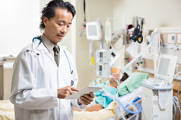 Image showing Doctor Examining Patient's Report On Digital Tablet