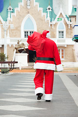 Image showing Santa Claus Carrying Bag While Walking In Courtyard