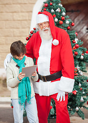 Image showing Santa Claus Standing With Boy Using Digital Tablet