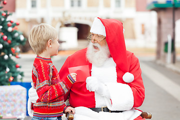 Image showing Boy Giving Wish List To Santa Claus