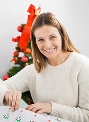 Image showing Happy Woman Wrapping Christmas Present