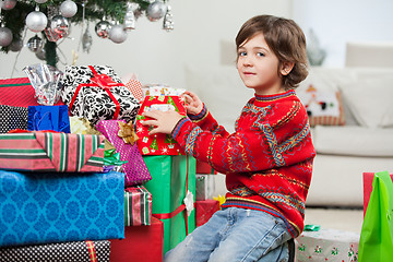 Image showing Cute Boy Kneeling By Christmas Gifts