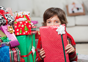 Image showing Boy Holding Christmas Gift In Front Of Face