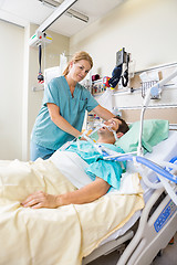 Image showing Nurse Adjusting Patient's Pillow In Hospital