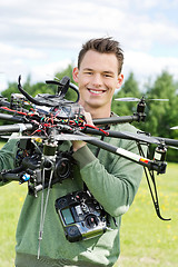 Image showing Young Engineer Holding UAV Helicopter