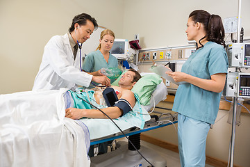Image showing Nurses And Doctor Examining Male Patient