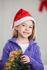 Image showing Smiling Girl Holding Tinsels During Christmas