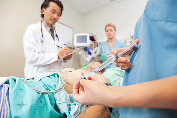 Image showing Nurse Injecting Dosage In IV Tube