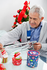 Image showing Man Wrapping Christmas Present