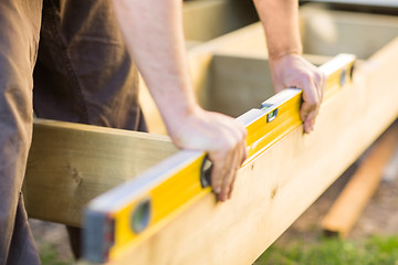 Image showing Carpenter's Hands Checking Level Of Wood At Site