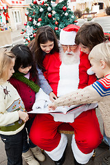 Image showing Santa Claus With Children Pointing At Book