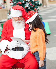 Image showing Girl And Santa Claus Using Digital Tablet