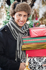 Image showing Happy Man Carrying Stacked Gift Boxes