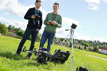 Image showing Technicians Holding Remote Controls Of UAV