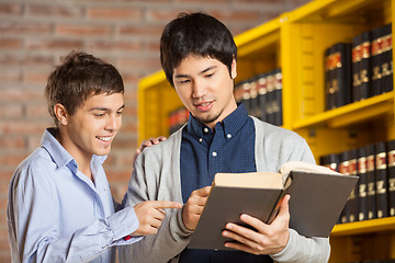 Image showing Friends Reading Book In College Library