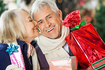 Image showing Woman About To Kiss Man Holding Christmas Presents