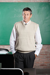 Image showing Teacher With Hands In Pockets Looking Away In Classroom