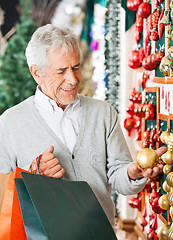 Image showing Man Choosing Christmas Ornaments