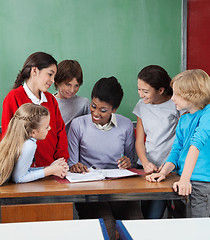 Image showing Female Professor Teaching Students At Desk