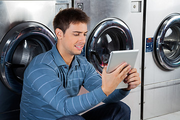 Image showing Man Using Digital Tablet At Laundry