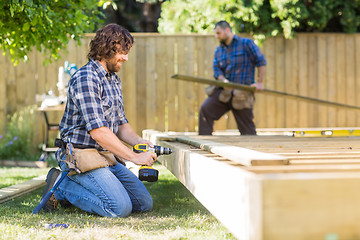 Image showing Manual Worker Drilling Wood At Construction Site