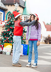 Image showing Boy Putting Santa Hat On Girl's Head