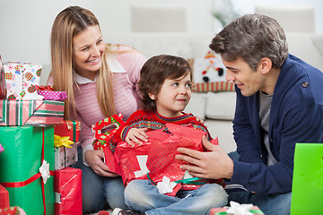 Image showing Parents With Son Opening Christmas Gift