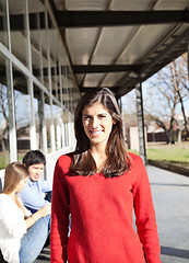 Image showing Woman Smiling With Students In Background On Campus