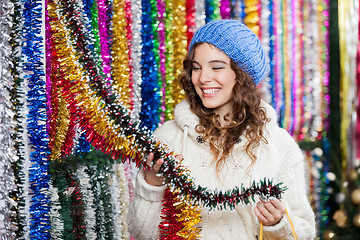 Image showing Young Woman Choosing Tinsels At Store